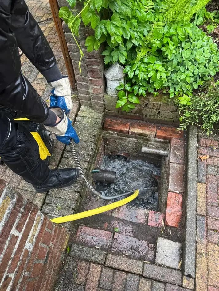 Monteur van 247Ontstopper ontstopt een verstopt riool met hogedrukapparatuur